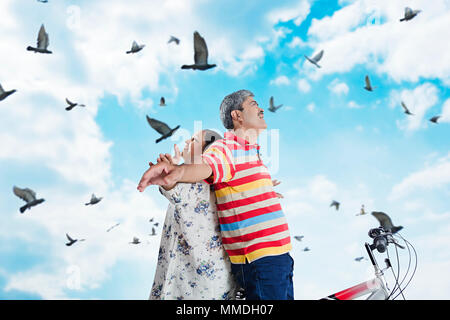 Happy Senior Couple Ensemble Fun Arms-Outstretched Cycle des promenades en plein air joyeux Banque D'Images