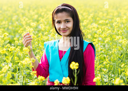 Un villageois Rural Adolescente Fleur Moutarde Champ Contrôle Village Banque D'Images