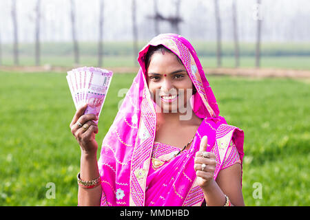 Un villageois Rural Femmes Thumbs-up avec billets roupies Revenu agricole Banque D'Images