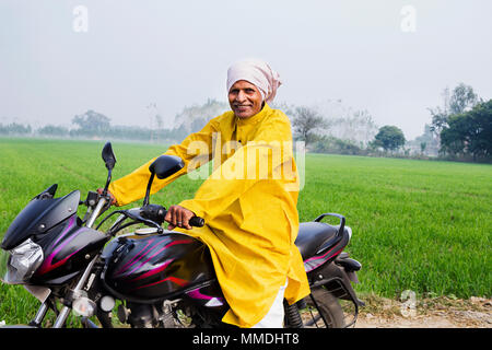 Un villageois Rural Senior Man Rides UNE In-Farm Moto Village Banque D'Images