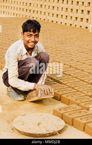 Jeune garçon faisant travailleur rural les briques Brick-Factory travaille à l'extérieur Banque D'Images
