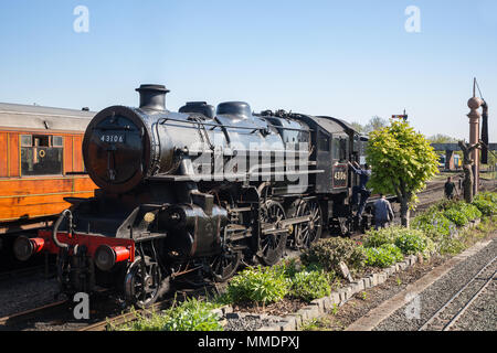 Ancienne locomotive à vapeur britannique dans les sidings, gare de Severn Valley Kidderminster, alors que l'équipage du train à vapeur, les travailleurs ferroviaires préparent une grue d'eau. Banque D'Images