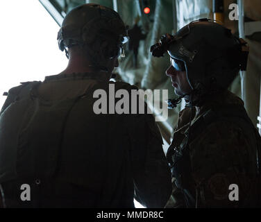 Une 320e de l'US Air Force Special Tactics Squadron de saut et 17e Escadron d'opérations spéciales l'arrimeur de discuter de sécurité avant d'opérations militaires d'une chute libre de l'US Air Force Commando MC-130J II 21 septembre 2017, à Kadena Air Base, au Japon. Le largage fonctions fournies par la 353e groupe d'opérations spéciales permet de sauvetage à long rayon d'action et de réaction rapide aux crises humanitaires ou de sécurité. (U.S. Air Force photo : Capt Jessica Tait) Banque D'Images