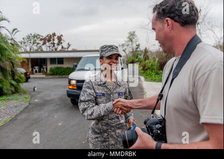 Edgar Rivera, une patrouille aérienne civile Cadet, sourire alors qu'il reçoit un patch du moral de l'unité à partir de la technologie. Le sergent Jose Rodriguez, 1er escadron de la Caméra de combat, après la livraison du matériel de secours d'urgence aux résidents locaux, Arecibo, Puerto Rico, le 18 octobre 2017. Arecibo est une municipalité de Puerto Rico, situé vers le centre de l'île et a été difficile d'accès depuis l'ouragan a laissé beaucoup de ses routes et ponts couverts de débris et endommagés par les glissements de terrain. (U.S. Photo de la Garde nationale aérienne par le sergent. Michelle Y. Alvarez-Rea) Banque D'Images