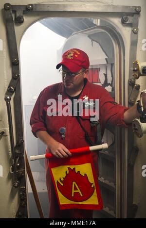 171023-N-QR145-002 La baie de Souda, Grèce (oct. 23, 2017) Technicien d'entretien des coques 1re classe Blake Willet simule un incendie au cours de la formation de contrôle des avaries à bord de la classe Arleigh Burke destroyer lance-missiles USS Porter (DDG 78) tandis qu'à la baie de Souda, la Grèce le 23 octobre 2017. Porter, l'avant-déployé à Rota, en Espagne, est sur sa quatrième patrouille dans la sixième flotte américaine zone d'opérations à l'appui des alliés et partenaires, et les intérêts de sécurité nationale des États-Unis en Europe. (U.S. Photo par marine Spécialiste de la communication de masse Krystina 3e classe Coffey/ libéré) Banque D'Images