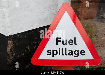 Triangulaire rouge et la sécurité routière les déversements de carburant avertissement signe un texte noir sur fond blanc contre wall with copy space Banque D'Images