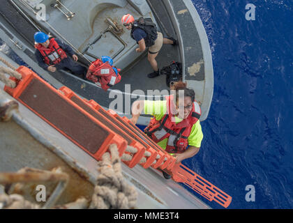 171025-N-UX013-177 OCÉAN PACIFIQUE (oct. 25, 2017) 2222 Fuiava, une Américaine mariner qui navigue depuis 5 mois sur un voilier endommagé, grimpe dans l'échelle de coupée à bord du navire de débarquement amphibie USS Ashland dock (LSD 48). Ashland, opérant dans la région du Pacifique-Indo-Asia sur un déploiement de routine, a secouru deux marins américains qui avaient été en détresse pendant plusieurs mois après leur voilier a eu une panne de moteur et s'était égarée et de son parcours d'origine en traversant l'océan Pacifique. (U.S. Photo par marine Spécialiste de la communication de masse d'argile et de Jonathan 3ème classe) Parution Banque D'Images