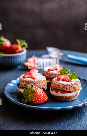 Mini Victoria sponge cakes traditionnels avec de la crème fouettée et les fraises Banque D'Images