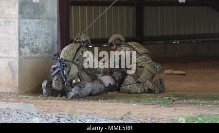 Deux membres de prendre soin d'un membre de l'équipe avec une simulation d'une blessure au cours des exercices de combat dans le cadre de l'exercice Le sud de grève 18 au Camp Shelby Joint Forces Training Center, près de Hattiesburg, au Mississippi, le 26 octobre 2017. L'exercice propose-air, air-sol, maritime et les forces d'opérations spéciales de formation. (U.S. Photo de la Garde nationale par la CPS. Christopher Shannon) Banque D'Images