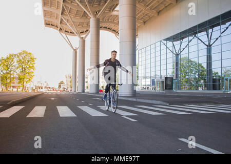 Le gars en chemise grise sur arrière-plan de la fenêtre. un jeune homme près de blue location. Pignon fixe urbain bike rider Banque D'Images