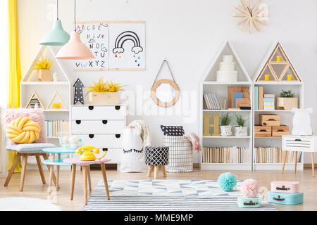 Deux affiches simple pendaison sur mur blanc dans la chambre d'enfant intérieur avec des meubles en bois, des paniers de matières et lampes pastel Banque D'Images