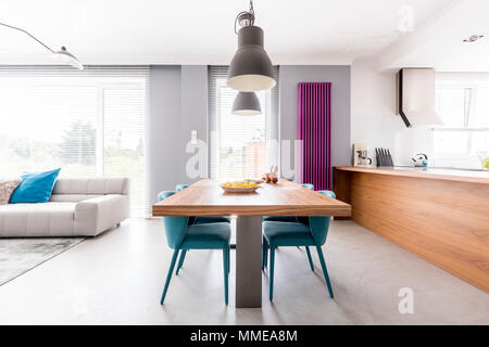 Appartement de l'espace de vie familiale avec cuisine en bois violet, radiateur, table avec chaises turquoise communale et spacieux salon r Banque D'Images