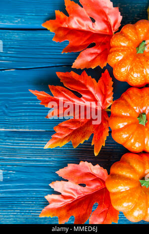 Close up trois citrouilles et feuilles d'érable artificiel bleu sur fond de bois concept d'automne Banque D'Images