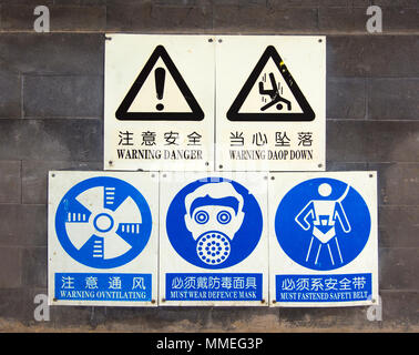 Signes chinois avec des traductions en anglais (certains incorrectement l'épeautre) sur un mur dans une banlieue de Pékin, en Chine. Banque D'Images