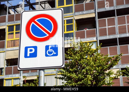 Stationnement pour handicapés en fauteuil roulant et signe ainsi et symboles d'avertissement sur un poteau les automobilistes Banque D'Images