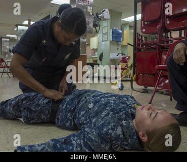 180511-N-NH199-0134 de l'OCÉAN PACIFIQUE (11 mai 2018) Hospital Corpsman 1re classe Stacie Coursey (à gauche), de Fairfield, Californie applique un garrot pendant un combat tactique soins de la causalité (TCCC) transport maritime militaire bien sûr à bord de navire-hôpital USNS Mercy commande (T-AH 19), le 10 mai 2018. La miséricorde est actuellement déployé à l'appui de Partenariat du Pacifique 2018 (PP18). PP18's mission est de travailler ensemble avec l'hôte et les pays partenaires à améliorer l'interopérabilité régionale et de capacités de réaction aux catastrophes, d'accroître la stabilité et la sécurité dans la région, et de favoriser de nouvelles amitiés et durable dans toute la région indo- Banque D'Images