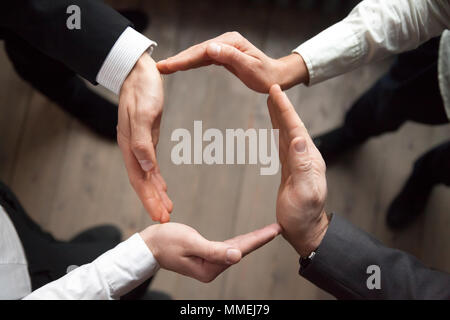 Les gens d'affaires inscrivez-vous les mains en cercle, protection et appui con Banque D'Images
