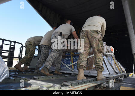 Aviateurs de la 193e Escadre d'opérations spéciales de l'antenne du Port, Middletown, Connecticut, charger des cargaisons sur une CL-130H Hercules, à partir de la 109e Escadre de transport aérien, Schenectady, New York, 25 octobre 2017. L'aéronef est utilisé pour envoyer les 201e Escadron Cheval Rouge aviateurs à Sainte-Croix, les Îles Vierges des États-Unis à l'appui de l'Ouragan Maria's relief et les efforts de reconstruction. Ils vont maintenir les tentes et les divers équipements utilisés dans l'aide en cas de catastrophe dans le lit pour système de répondeur. (U.S. Air National Guard photo par le Sgt. Matt Schwartz/libérés) Banque D'Images