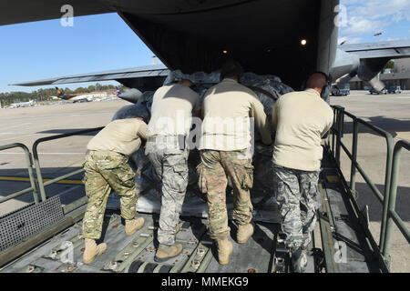 Aviateurs de la 193e Escadre d'opérations spéciales de l'antenne du Port, Middletown, Connecticut, charger des cargaisons sur une CL-130H Hercules, à partir de la 109e Escadre de transport aérien, Schenectady, New York, 25 octobre 2017. L'aéronef est utilisé pour envoyer les 201e Escadron Cheval Rouge aviateurs à Sainte-Croix, les Îles Vierges des États-Unis à l'appui de l'Ouragan Maria's relief et les efforts de reconstruction. Ils vont maintenir les tentes et les divers équipements utilisés dans l'aide en cas de catastrophe dans le lit pour système de répondeur. (U.S. Air National Guard photo par le Sgt. Matt Schwartz/libérés) Banque D'Images