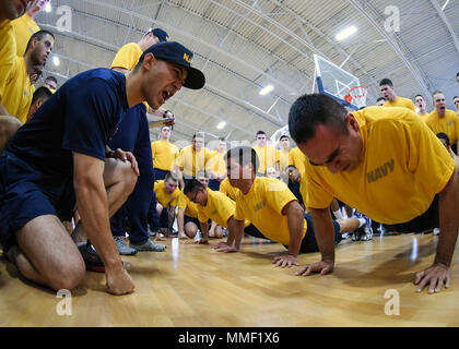 171028-N-IY633-297 GRANDS LACS, Illinois (oct. 28, 2017) Technicien électronique maître de 1re classe Alexander Rocha, gauche, motive les recrues au cours d'un push-up à la concurrence de la commande d'entraînement des recrues, gymnase de Freedom Hall. Recruter des divisions s'affrontent dans 10 différents événements de remise en forme pour gagner la Coupe du capitaine et l'occasion d'afficher le drapeau de la Coupe du capitaine à leur laissez-passer en revue. (U.S. Photo par marine Spécialiste de la communication de masse 1re classe Amanda S. Kitchner/libérés) Banque D'Images