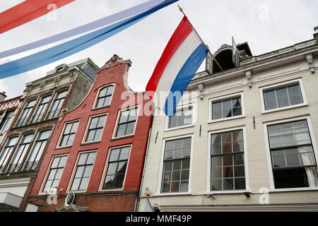 Brandir le drapeau néerlandais sur la façade d'un bâtiment ancien à Leeuwarden Banque D'Images
