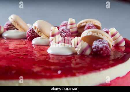 Décoration avec des framboises, des chocolats et des biscuits sur un gâteau Banque D'Images