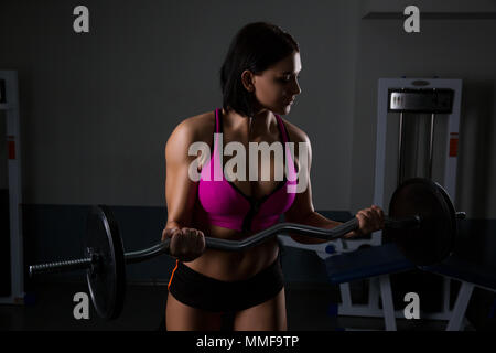 Femme dans la salle de sport de l'athlète. Ascenseurs haltère, concept halthy Banque D'Images