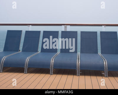 Chaises longues dans une rangée sur le pont d'un navire de croisière Banque D'Images