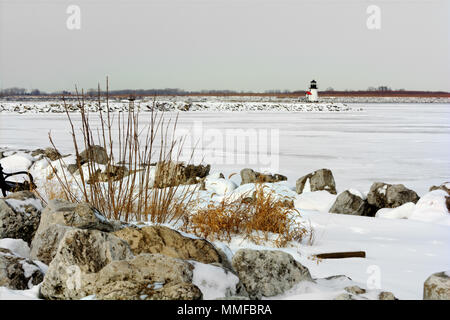 Un petit phare à l'entrée du port de Toledo (Ohio) en hiver. Le lac Érié est gelé et recouvert de neige dans cette scène d'hiver. Banque D'Images