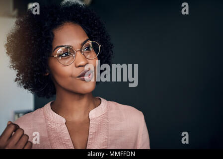 Smiling African businesswoman wearing glasses avoir une conversation avec un collègue de travail dans un bureau moderne Banque D'Images