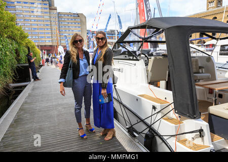 St Katherine Docks, Londres, 11 mai 2018. Deux jeunes femmes profitez d'une promenade dans les yachts de luxe au soleil. Maintenant à sa quatrième année et tenue à l'emblématique marina à côté du coeur de la ville de Londres et du Tower Bridge, Londres est une une un Boat Show et festival, où les yachts, bateaux, voitures et une foule d'autres entreprises peuvent être envisagées à la fois sur l'eau et sur terre. Il s'étend du 10 au 12 mai. Credit : Imageplotter News et Sports/Alamy Live News Banque D'Images