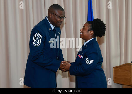 Le sergent-chef en chef. Henry Hayes, Jr., chef du commandement Hanscom, félicite les hauts d'un membre de l'Amber Clayton, 66e Escadron médical technicien de la santé mentale, au cours d'un collège communautaire de la Force aérienne à la cérémonie de remise des communes à l'Minuteman Hanscom Air Force Base, Mass., 17 octobre. Le FACC est un des grades à charte fédérale de l'institution au service de l'US Air Force a enrôlé de force totale. (U.S. Air Force photo par Mark Herlihy) Banque D'Images