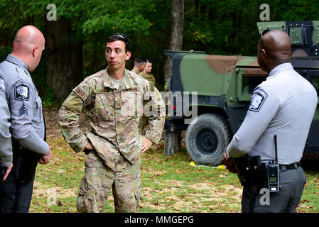 Tech. Le Sgt. Derek Horn, 4e Escadron de génie civil sous-officier responsable de l'élimination des explosifs et munitions, formation, centre et des agents de la Wayne County Sheriff's Office discuter des options pour l'élimination des munitions non explosées trouvées dans un hangar, le 12 octobre 2017, à Goldsboro, Caroline du Nord. Environ 50 livres de UXO ont été éliminés de façon sécuritaire sans incident à une gamme d'armes à feu. (U.S. Air Force photo par un membre de la 1re classe Kenneth Boyton) Banque D'Images