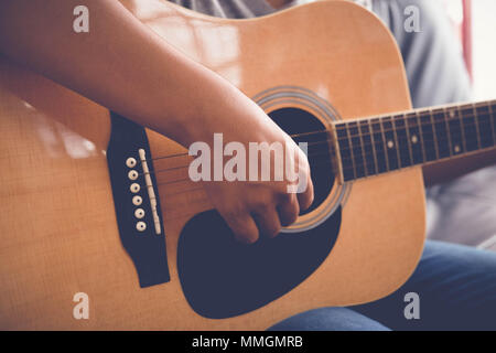 Woman's hands playing acoustic guitar avec effet de filtre style vintage retro Banque D'Images