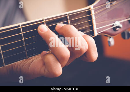 Woman's hands playing acoustic guitar avec effet de filtre style vintage retro Banque D'Images