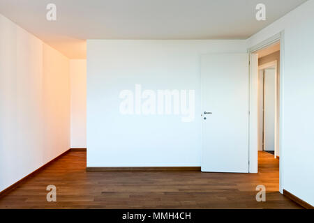 Chambre vide de l'intérieur, murs blancs, parquet au sol Banque D'Images