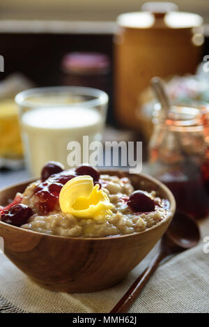 Gruau porrige avec beurre et confiture de cerise sur le tableau bleu. Avec le verre de lait. Le petit-déjeuner Banque D'Images