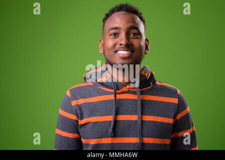 Beau jeune homme africain contre un arrière-plan vert Banque D'Images
