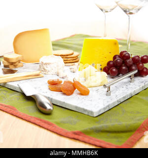 Plateau en marbre gris avec du fromage, des craquelins et des fruits Banque D'Images