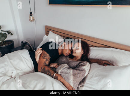 Jeune couple dormir paisiblement sur le lit dans la chambre. Couple en position couchée endormie. Banque D'Images