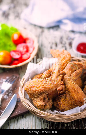 Ailes de poulet frites et ketchup sur fond de bois Banque D'Images