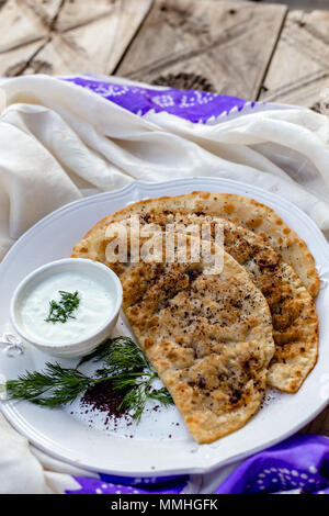 Une cuisine azerbaïdjanaise traditionnels. Qutabs sur pain plat en céramique blanche. Composition verticale. Banque D'Images