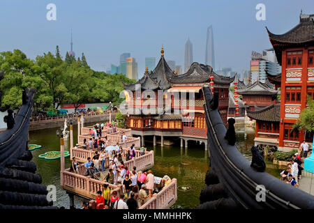 Chine.Shanghai : Yu Yuan Bazar. Pont en zigzag et Huxinting Tea House. L'horizon de Pudong en arrière-plan. Banque D'Images