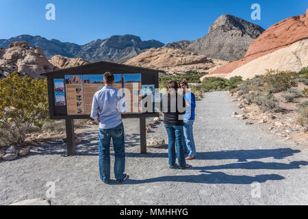 Les visiteurs du parc à la recherche d'information à signer le long du sentier de randonnée à Red Rock Canyon National Conservation Area en dehors de Las Vegas, Nevada Banque D'Images