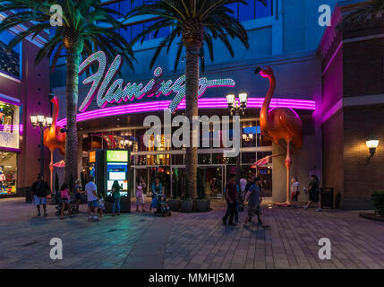 Les touristes passant par le violet et rose néon à l'entrée de l'hôtel Flamingo Las Vegas et Casino sur le Strip de Las Vegas dans le Paradis, au Nevada Banque D'Images