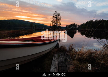 Bateau prêt pour la pêche dans un lac calme avec un beau coucher de soleil en Suède Mai 2018 Banque D'Images