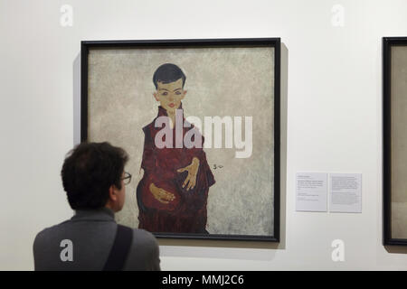 Visiteur en face de la peinture 'La Reiner Boy' (1910) par le peintre expressionniste autrichien Egon Schiele affiché dans le Musée du Belvédère à Vienne, Autriche. Herbert Reiner à l'âge autour de six est représenté dans le portrait. Banque D'Images