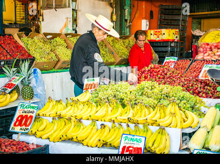 Vieux vendant des bananes, des fraises et des raisins portant un chapeau de paille chilien traditionnel, marché aux fruits et légumes Patronata, Santiago, Chili Banque D'Images