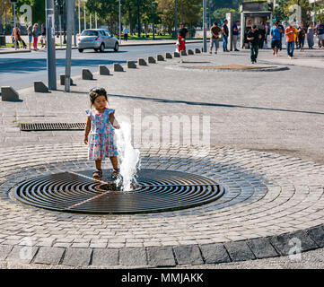 Petite fille jouant avec une fontaine à l'extérieur du bâtiment du Marché Central, Santiago, Chili Banque D'Images