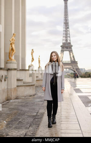 Jeune femme debout sur la place du Trocadéro près de statues dorées et Tour Eiffel. Banque D'Images